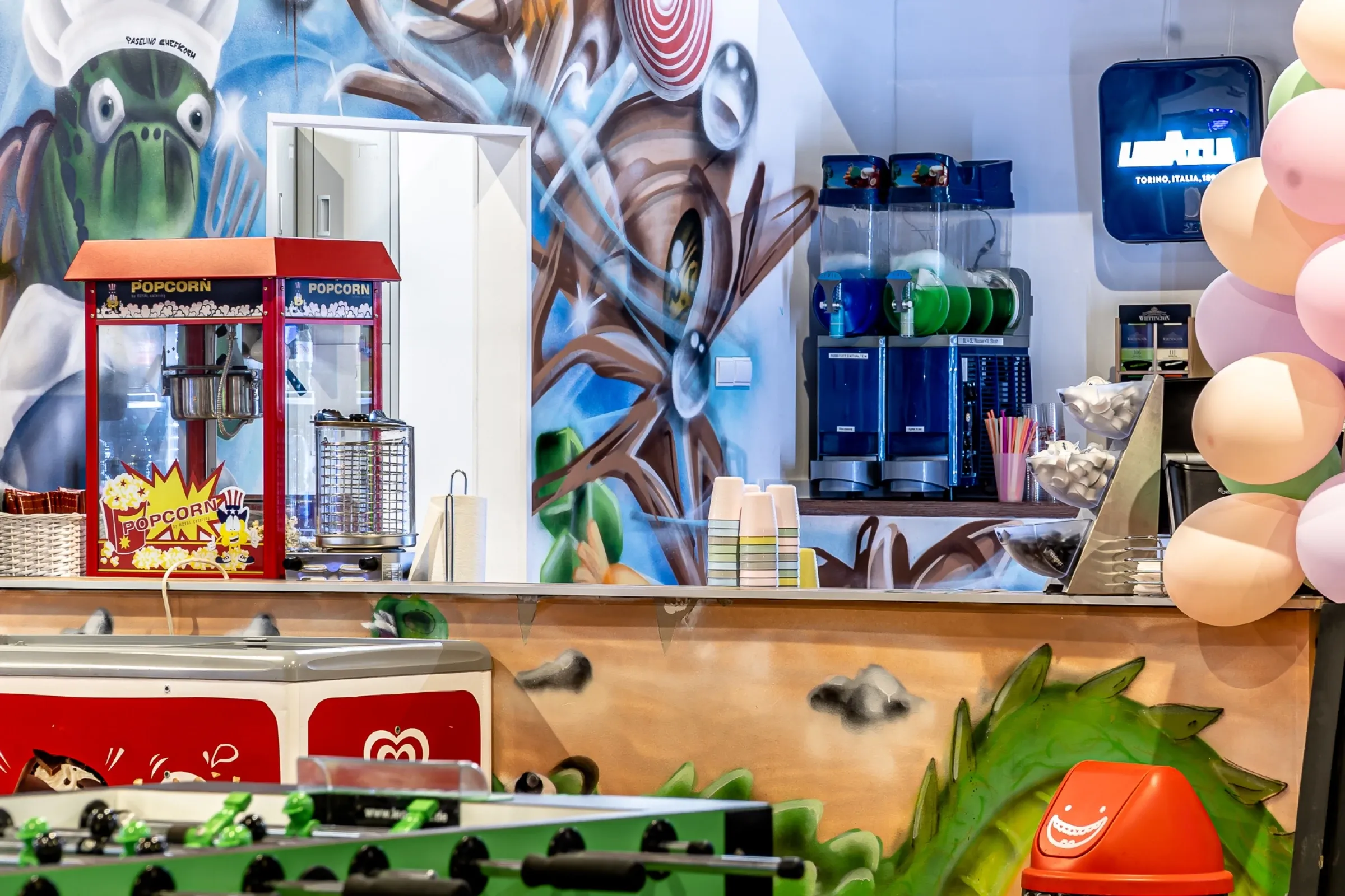 Kiosk mit Popcornmaschine und Kraken-Wandbild
