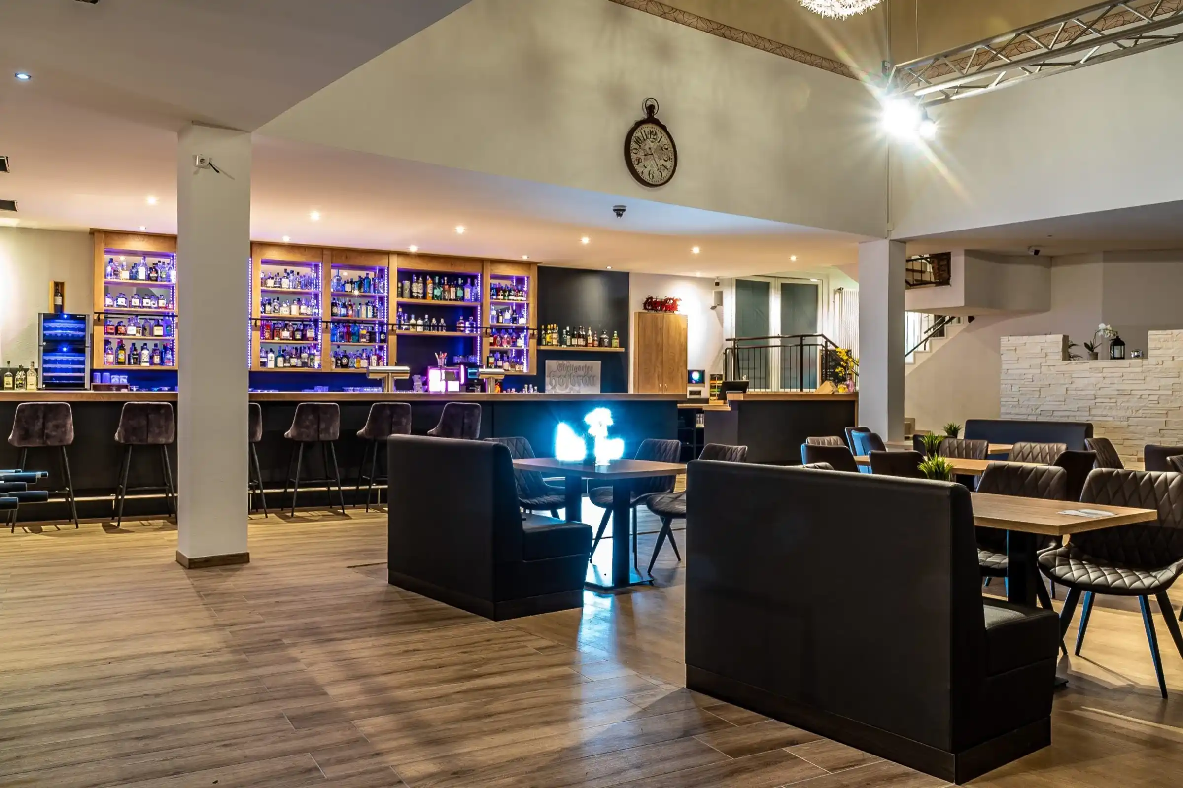 Bar mit beleuchteten Gin-Regalen und Lounge im Paselino Restaurant